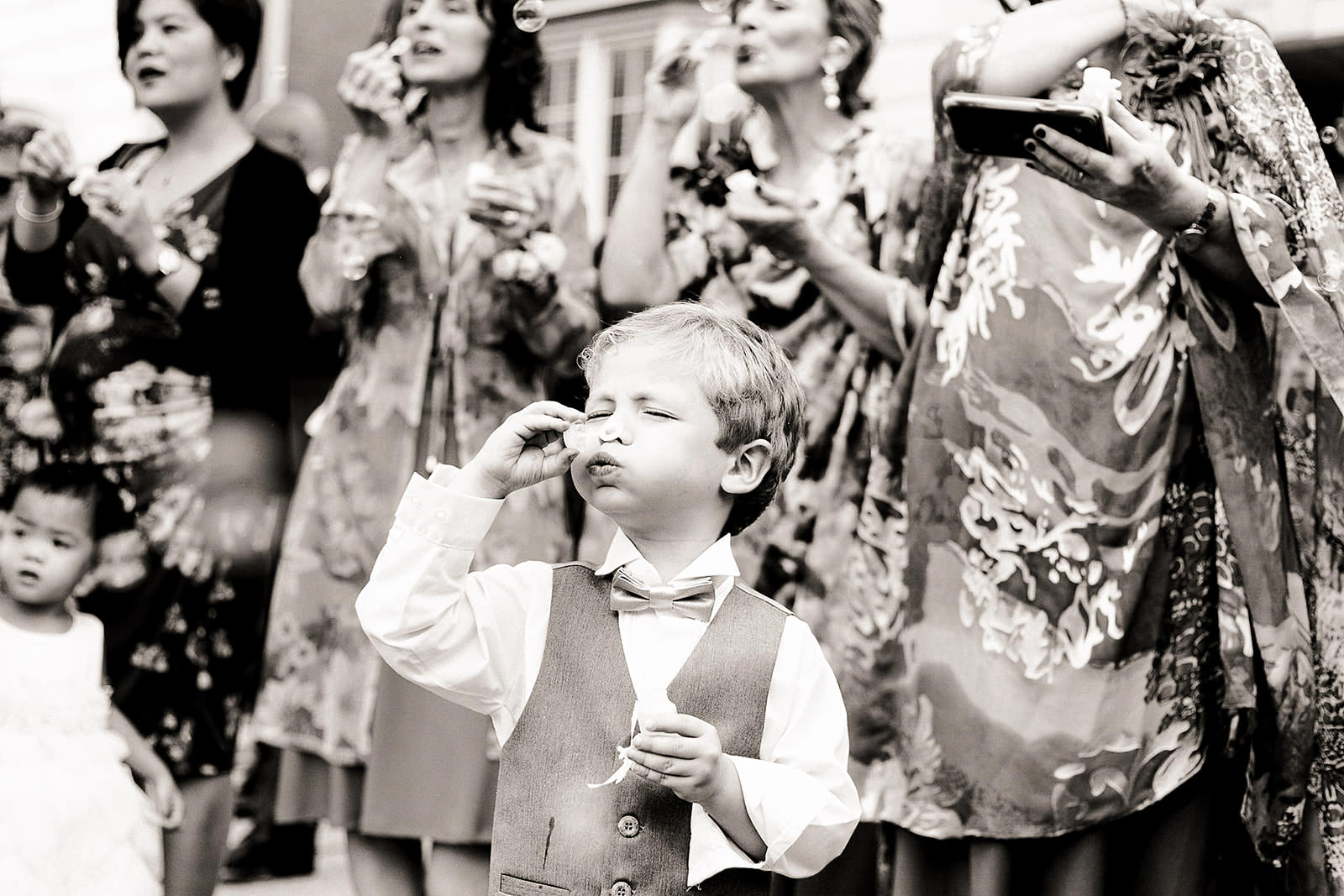 Cute little boy blowing bubbles at wedding